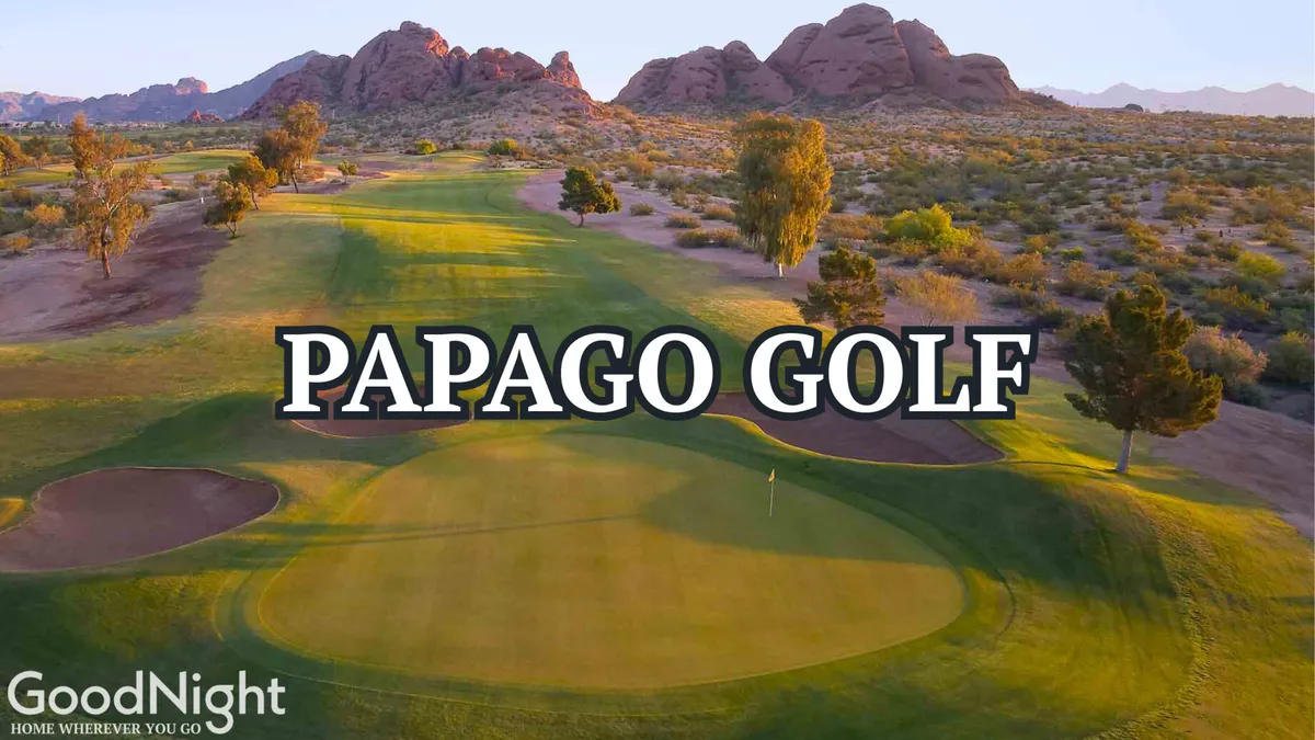 A lush green golf course stretches across the foreground, framed by a dramatic mountain backdrop beneath a clear Arizona sky. The scene exudes a sense of leisure and camaraderie, with manicured fairways inviting groups to play and socialize outdoors.